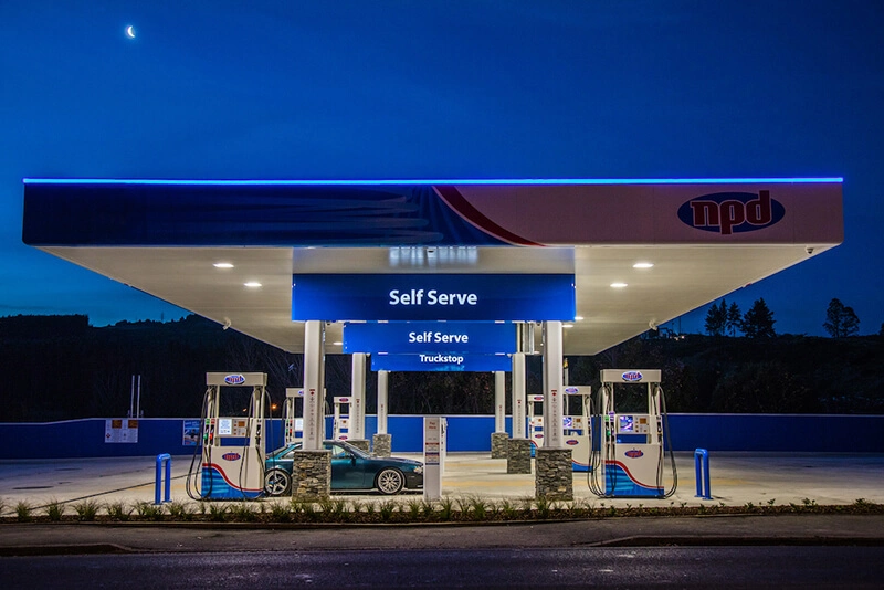NPD self-serve fuel station at dusk with a vehicle refuelling under the canopy